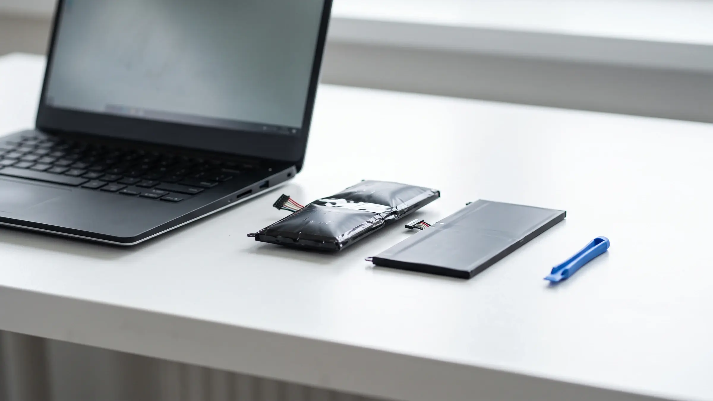 Schlanker schwarzer Aluminium-Laptop mit aufgeblähtem Akku – Razer Blade Reparatur